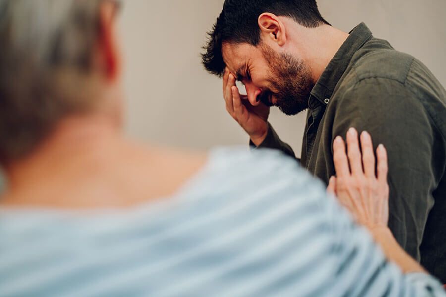 A family member reaches out to comfort a loved one during an intervention.