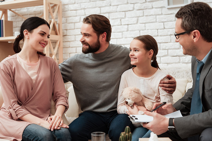 A family speaks with a family therapist in an office.