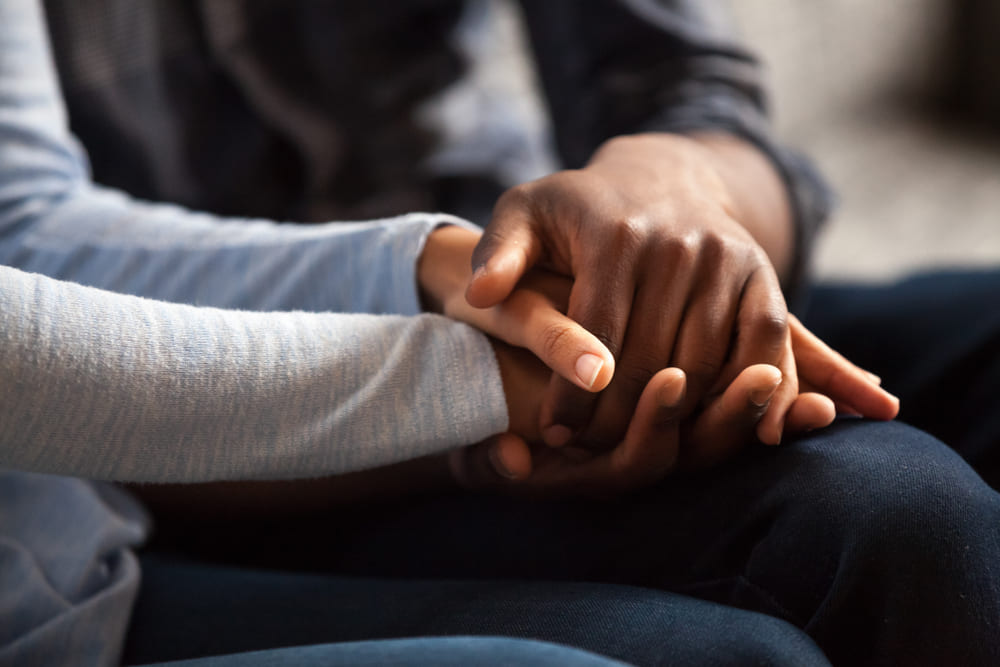 A couple holding hands symbolizing support