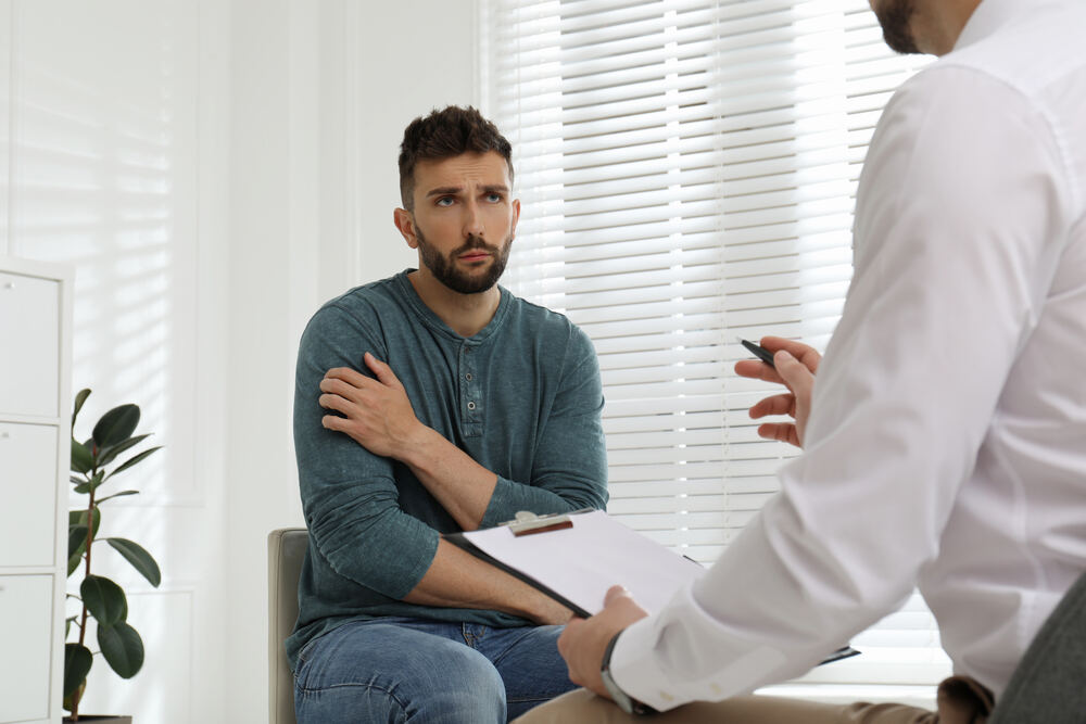 A doctor speaking to a man about drug rehab