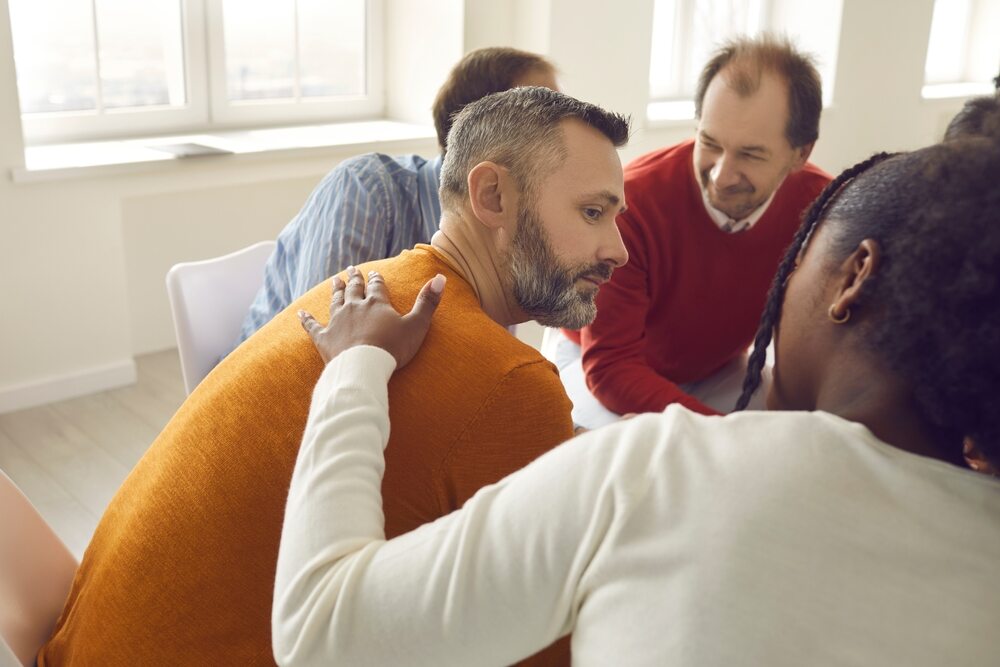 A person being comforted in group therapy